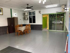 馬六甲的住宿－83 Homestay，配有桌椅和绿门的房间