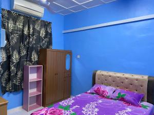 a bedroom with a bed and a small cabinet at 83 Homestay in Melaka