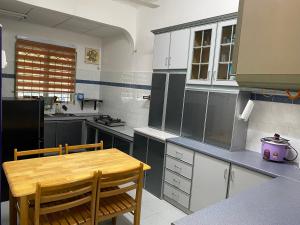 a kitchen with a wooden table and chairs in it at 83 Homestay in Melaka