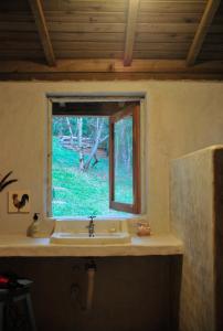 a bathroom with a sink and a window at Chalé Paiol - Sítio Lajinha in Alagoa
