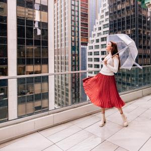 a woman in a red skirt holding an umbrella on a building at Hotel Indigo NYC Downtown - Wall Street, an IHG Hotel in New York