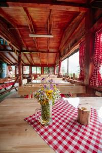 uma mesa com um vaso de flores numa toalha de mesa xadrez em Komovi - Kobil Do Guesthouse em Kolašin