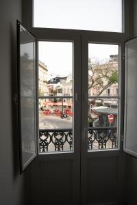 a window with a view of a city street at Guest House Jacarandá Faro in Faro