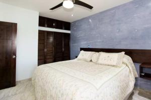 a bedroom with a large bed with a blue wall at Central located in Flamingo, Condo with gorgeous views - Flamingo Marina Resort in Playa Flamingo