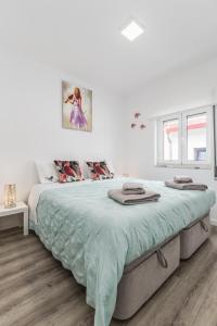 - une chambre blanche dotée d'un grand lit avec des draps verts dans l'établissement Casa do Barqueiro - Porto - Quinta da Cabrida, à Porto