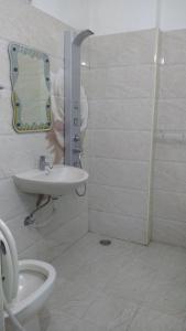 a bathroom with a toilet and a sink and a mirror at Hitech Shilparamam Guest House in Hyderabad