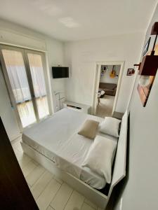 ein weißes Schlafzimmer mit einem großen Bett in einem Zimmer in der Unterkunft Rooftop big Terrace fiera MIlano/Portello in Mailand