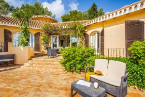 a home with a patio with chairs and a house at Villa Tinamar 29 in Cartagena