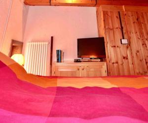 a bedroom with a bed and a flat screen tv at * Chalet inside the nature* [12 guests + WI-FI] in Siror
