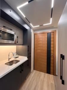 a bathroom with a sink and a wooden door at Aley Suites in Aley