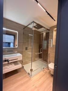 a bathroom with a glass shower and a toilet at Aley Suites in Aley