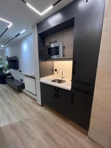 a kitchen with a sink and a microwave at Aley Suites in Aley