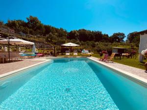 a large swimming pool with blue water in a yard at Appartamenti l'Olivo in Bagnone