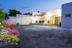 a courtyard of a house with a table and flowers at Casa Vacanze da Nino in Torre Lapillo