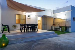 a patio with a table and chairs in a house at Casa Vacanze da Nino in Torre Lapillo