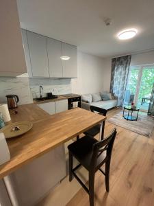 een keuken en een woonkamer met een tafel en een bank bij Komfort z balkonem w centrum in Wrocław
