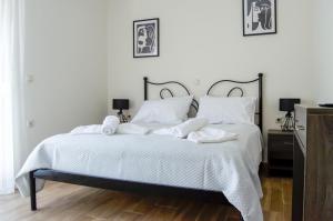a bedroom with a bed with white sheets and pillows at The Three Sisters House in Kardamaina