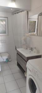 een witte badkamer met een wasmachine bij Chalet Sol y Sombra in Pals