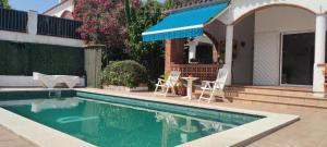 a swimming pool with two chairs and a house at Chalet Sol y Sombra in Pals