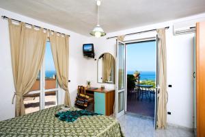 Schlafzimmer mit einem Bett und Meerblick in der Unterkunft Poggio Del Sole in Ischia