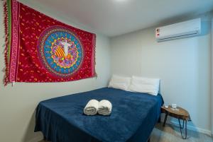 a bedroom with a bed with a red tapestry at Secreto Quartos in Rio de Janeiro