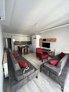 een woonkamer met 2 banken en rode stoelen bij Ansar Suite شقق الأنصار in Trabzon
