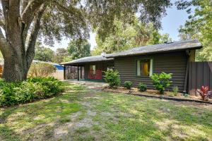 una pequeña casa con un árbol y un patio en Riverfront Cottage in Homosassa Chateau Relaxo, en Homosassa