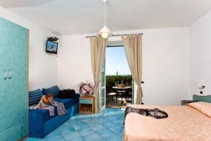 een slaapkamer met een bed, een bank en een tafel bij Sunny Hill in Ischia