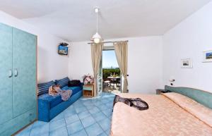 ein Schlafzimmer mit einem Bett und einem blauen Sofa in der Unterkunft Poggio Del Sole in Ischia