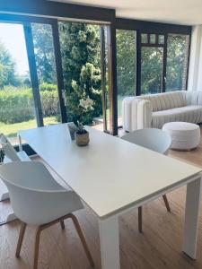 einen weißen Tisch und Stühle im Wohnzimmer in der Unterkunft Chalet au pays de Herve in Herve