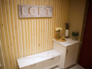 La salle de bains est pourvue de toilettes et d'un panneau mural. dans l'établissement Le Moment Bien-Être - Appartement avec SPA privatif, à Saint-Omer