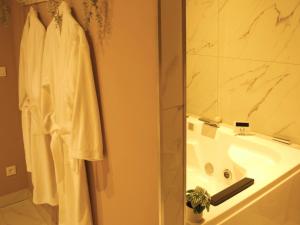 La salle de bains est pourvue d'un lavabo, d'une douche et d'une serviette. dans l'établissement Le Moment Bien-Être - Appartement avec SPA privatif, à Saint-Omer