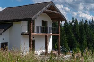 a house with a balcony on the side of it at Chillax Chalet in Yablunytsya
