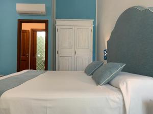een slaapkamer met een wit bed en blauwe muren bij Relais BeneMari in Siniscola