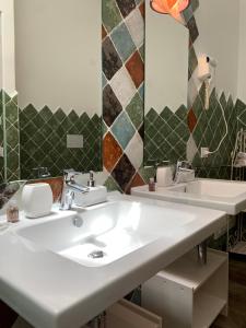 een badkamer met 2 wastafels en een spiegel bij Relais BeneMari in Siniscola