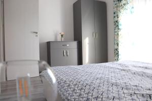 a bedroom with a bed and a dresser and a window at Apart Relax Baile Felix in Cordău