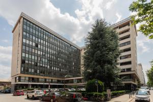 a large building with cars parked in a parking lot at Garden Palace by Wonderful Italy - Apartment in Turin