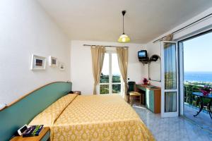 ein Schlafzimmer mit einem Bett und einem Balkon in der Unterkunft Poggio Del Sole in Ischia