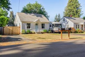 a house with a truck parked in the yard at Charming Eugene Retreat Private Hot Tub and Yard! in Eugene