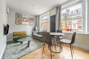 Central London Apartment في لندن: غرفة معيشة مع أريكة وطاولة وكراسي