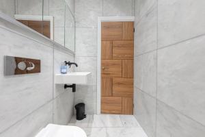 Central London Apartment في لندن: حمام مع حوض وباب خشبي