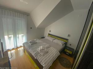 a bedroom with a bed with a white bedspread at Apartman Olivia in Ludbreg