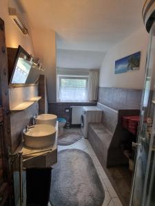 a bathroom with a sink and a toilet and a tub at Pension Zum Burgwächter in Rahden