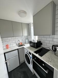 a small kitchen with a washer and a sink at Central studioflat Chelsea in London