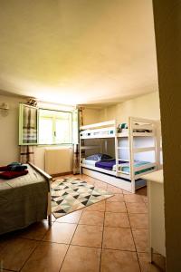 um quarto com 2 beliches e piso em azulejo em la maison du Vial em Revest-les-Roches