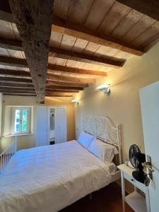 - une chambre avec un lit blanc et un plafond en bois dans l'établissement Borgo BiancoMatilde - Boutique Hotel, à Casina