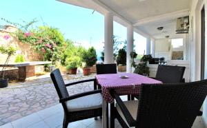 a patio with a table and chairs on a porch at Apartmani Kljajevic Sutomore in Bar