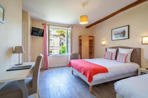 Schlafzimmer mit einem Bett, einem Schreibtisch und einem Fenster in der Unterkunft Hotel Val De Loire in Azay-le-Rideau