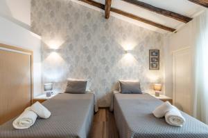 two beds in a room with two lamps on the wall at Casa do Jornaleiro - Douro in Casal de Loivos