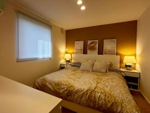 a bedroom with a bed with two lamps and a window at Vacanza Resort in Gifu
